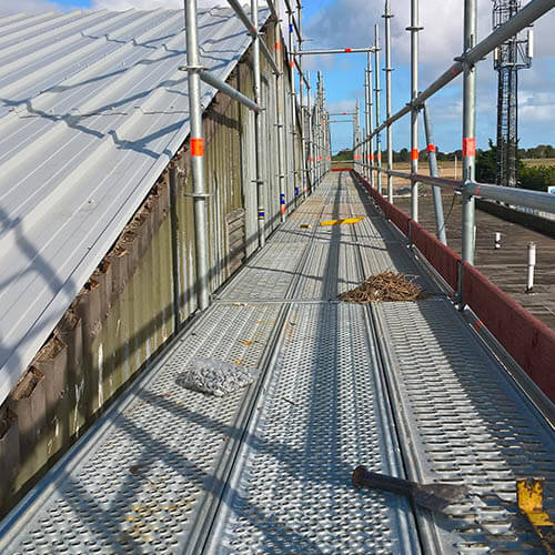 An independant gable scaffolding complete with a non-slip walkway not only complies with HSE recommendations but is safer than using cheaper edge protection as the old fragile roof becomes the walkway.
